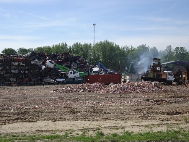 A scrapyard where something is working hard, producing a lot of smoke.