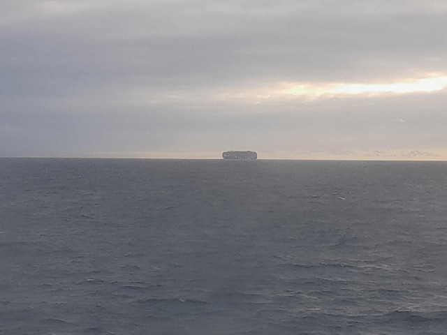 A featureless ship, probably a car transporter.