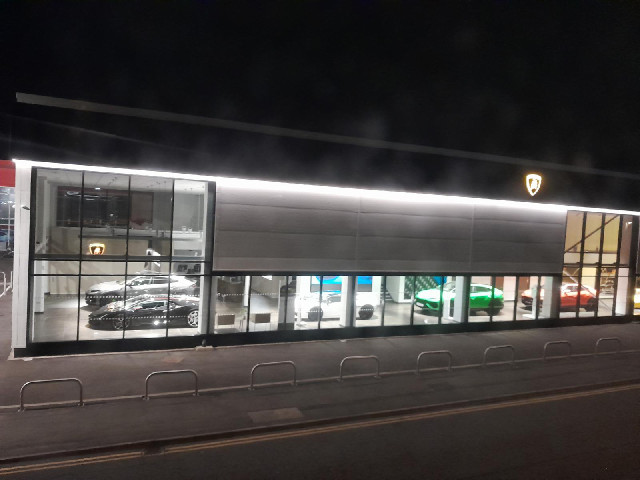 The view out of the window is of a Lamborghini garage.